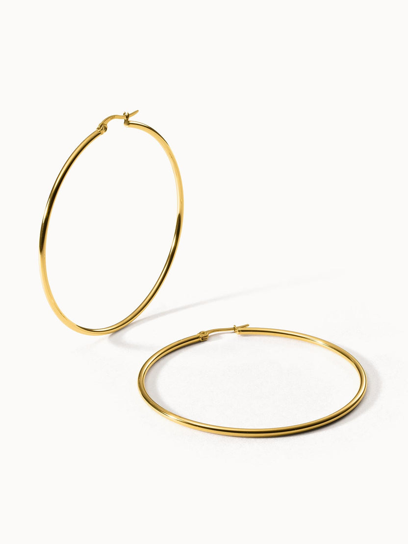 Goldene Creolen von PURELEI, elegant und zeitlos, auf hellem Hintergrund.