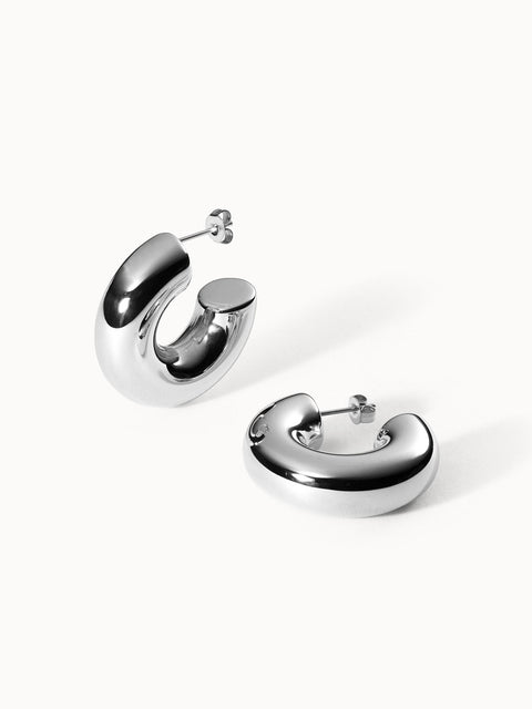Glänzende, nickelfreie Silbercreolen von PURELEI mit modernem, geschwungenem Design.