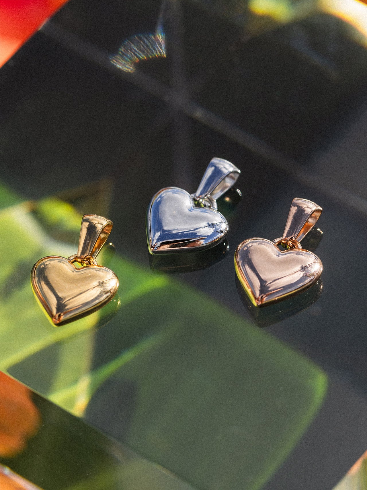 Herz-Anhänger aus Silber und Roségold auf grünem Hintergrund, PURELEI-Design.