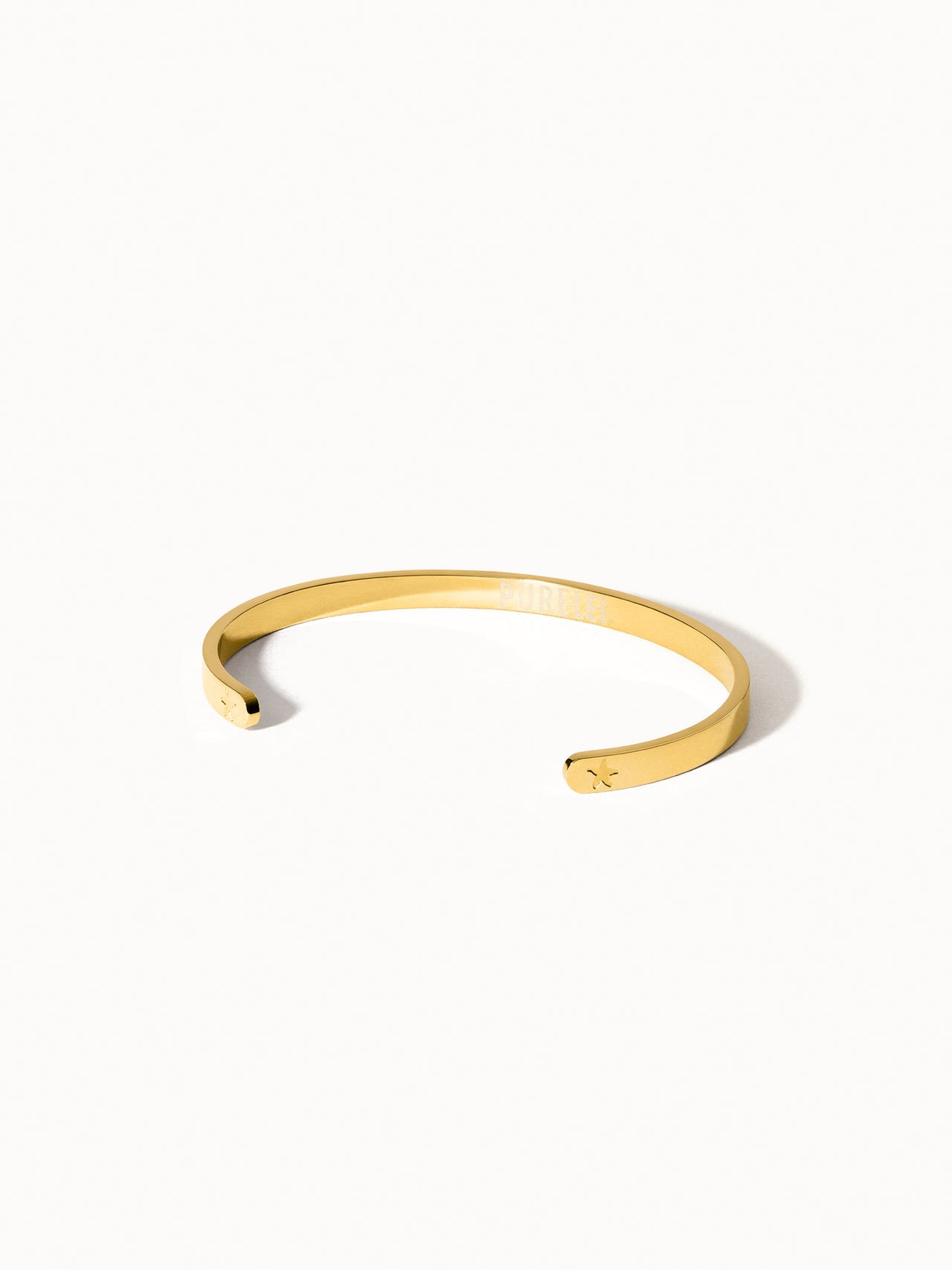 PURELEI Connection Armcuff aus goldfarbenem, nickelfreiem Metall mit minimalistischer Eleganz auf hellem Hintergrund