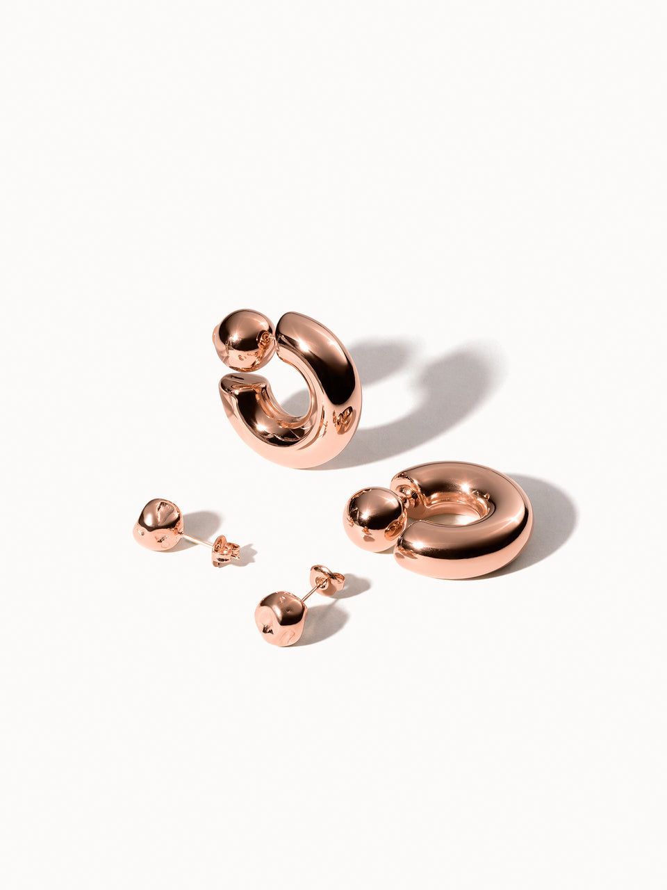 Roségoldene Creolen und Ohrstecker von PURELEI, elegant und modern mit glänzendem Finish.