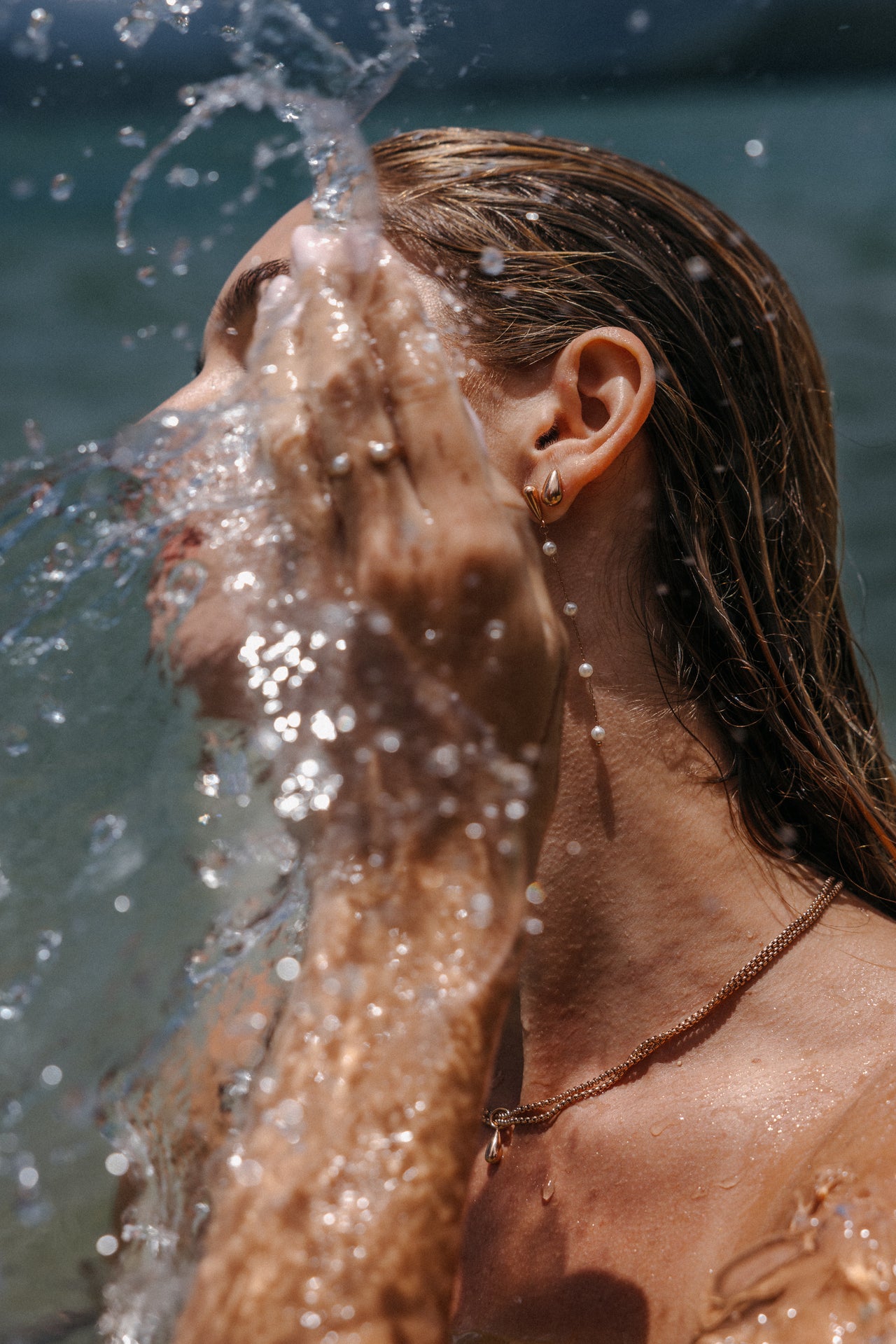 Wasserfestes, goldenes Halsband und Ohrringe mit Perlen, PURELEI, in tropischer Atmosphäre.