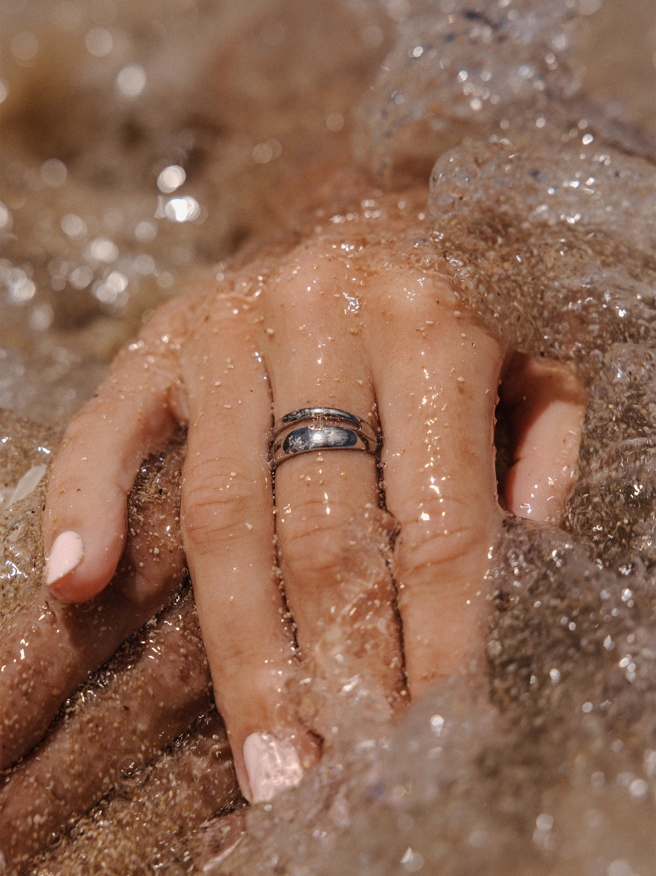 Silberner Ring von PURELEI, elegant im Wasser, umgeben von sanften Wellen.