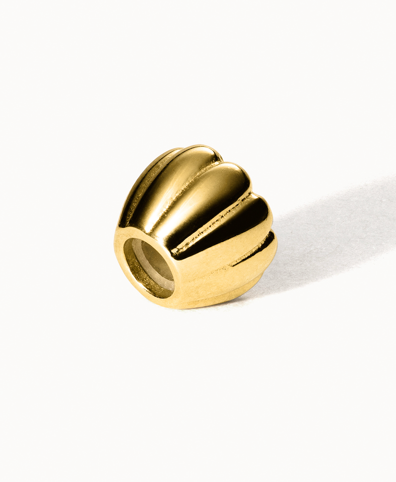 Goldene Muschel-Perle von PURELEI mit glänzender Oberfläche und eleganter Form.