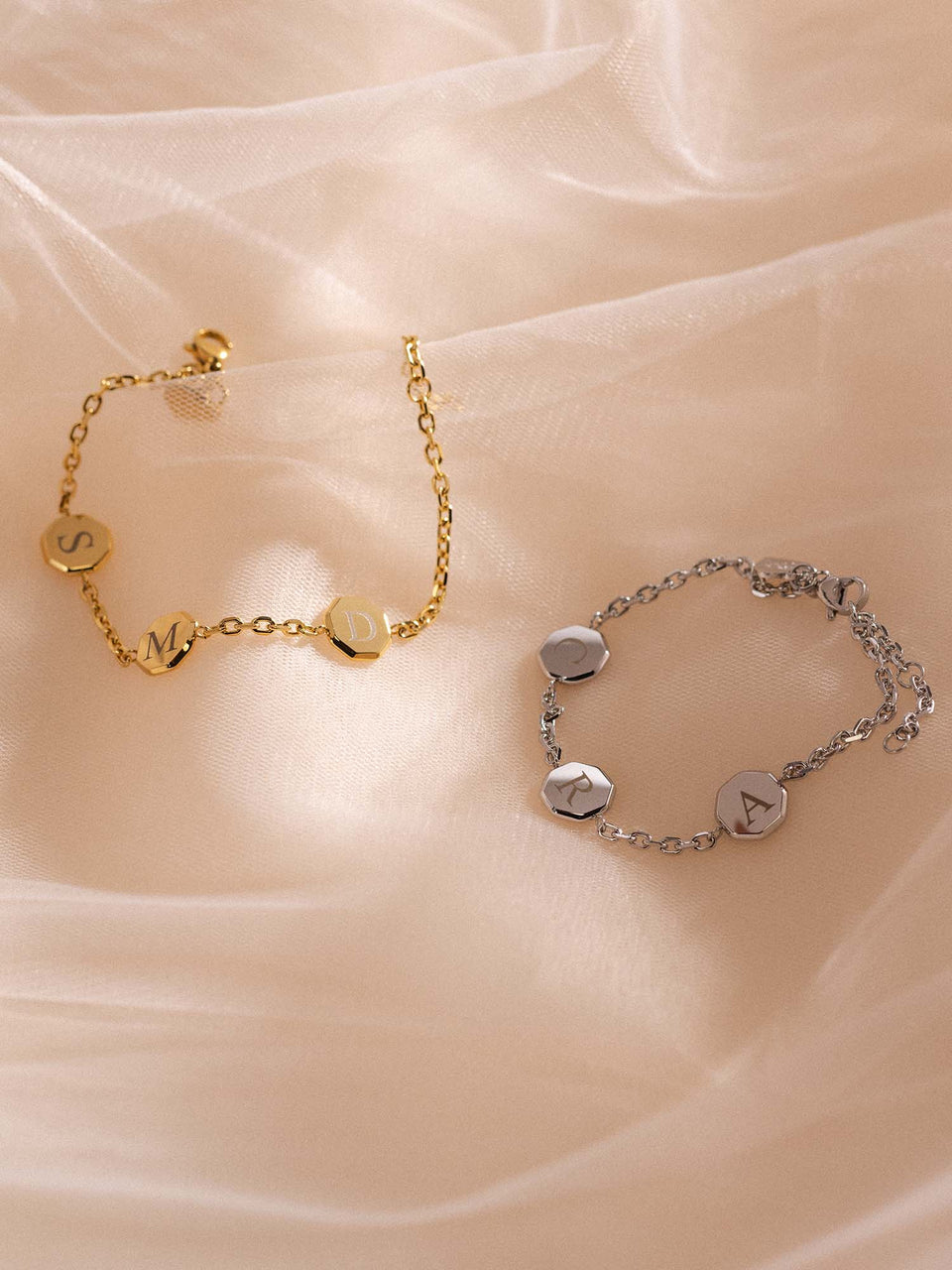 Eternal Connection Armband-Set von PURELEI in Gold und Silber mit gravierten Anhängern auf zartem Stoff, elegant und feminin.