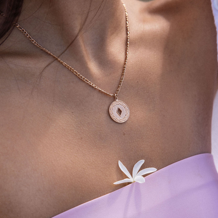 Lolani Kette von PURELEI in Roségold mit gemustertem Coin-Anhänger, elegant am Hals getragen, feminine Leichtigkeit.