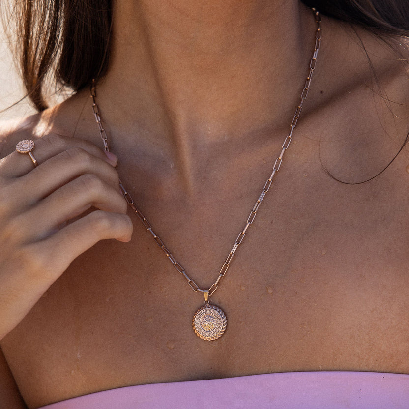 PURELEI Waina Ring in Roségold mit filigranem Coin, getragen in natürlichem Sonnenlicht, elegant und feminin.