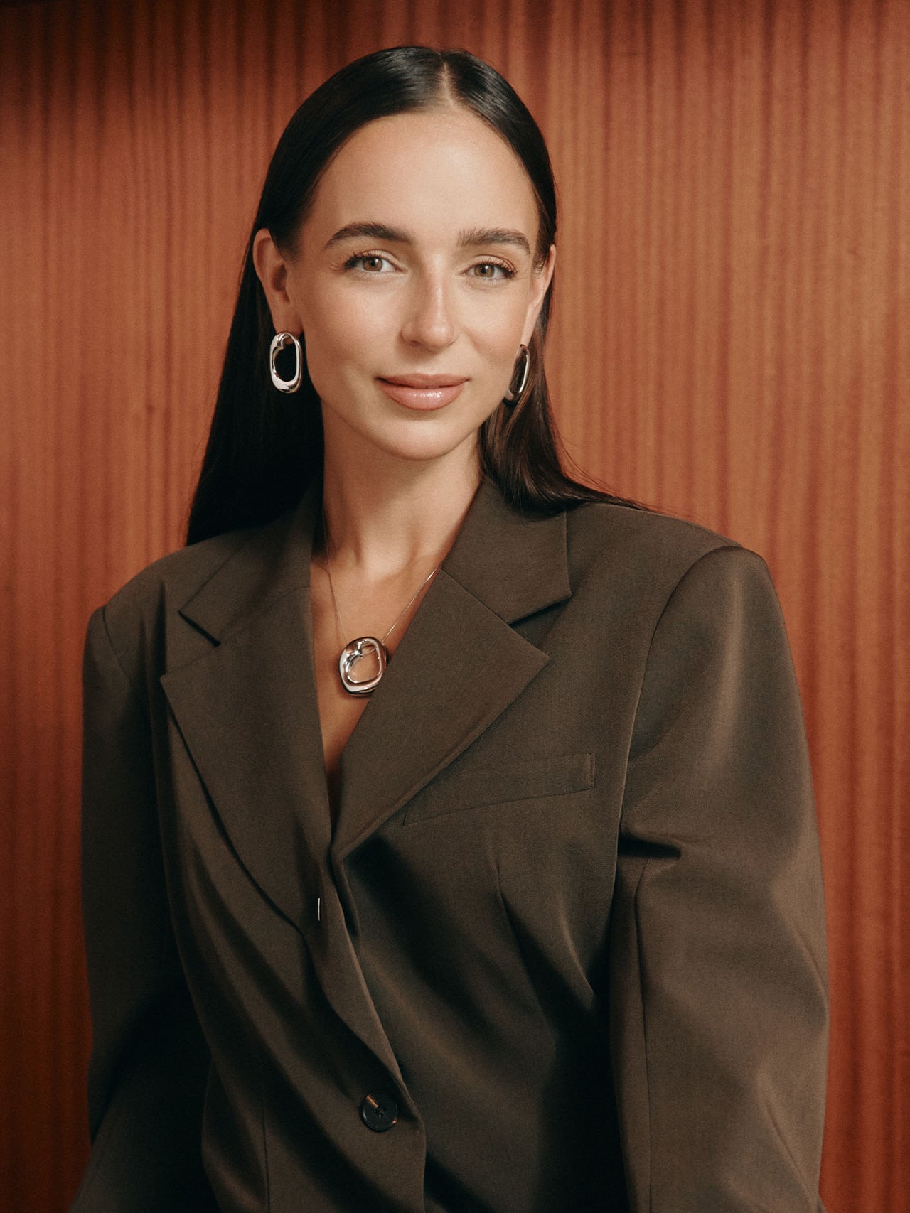 Elegante, goldene Ohrringe und Kette von PURELEI, getragen in warmem Licht.