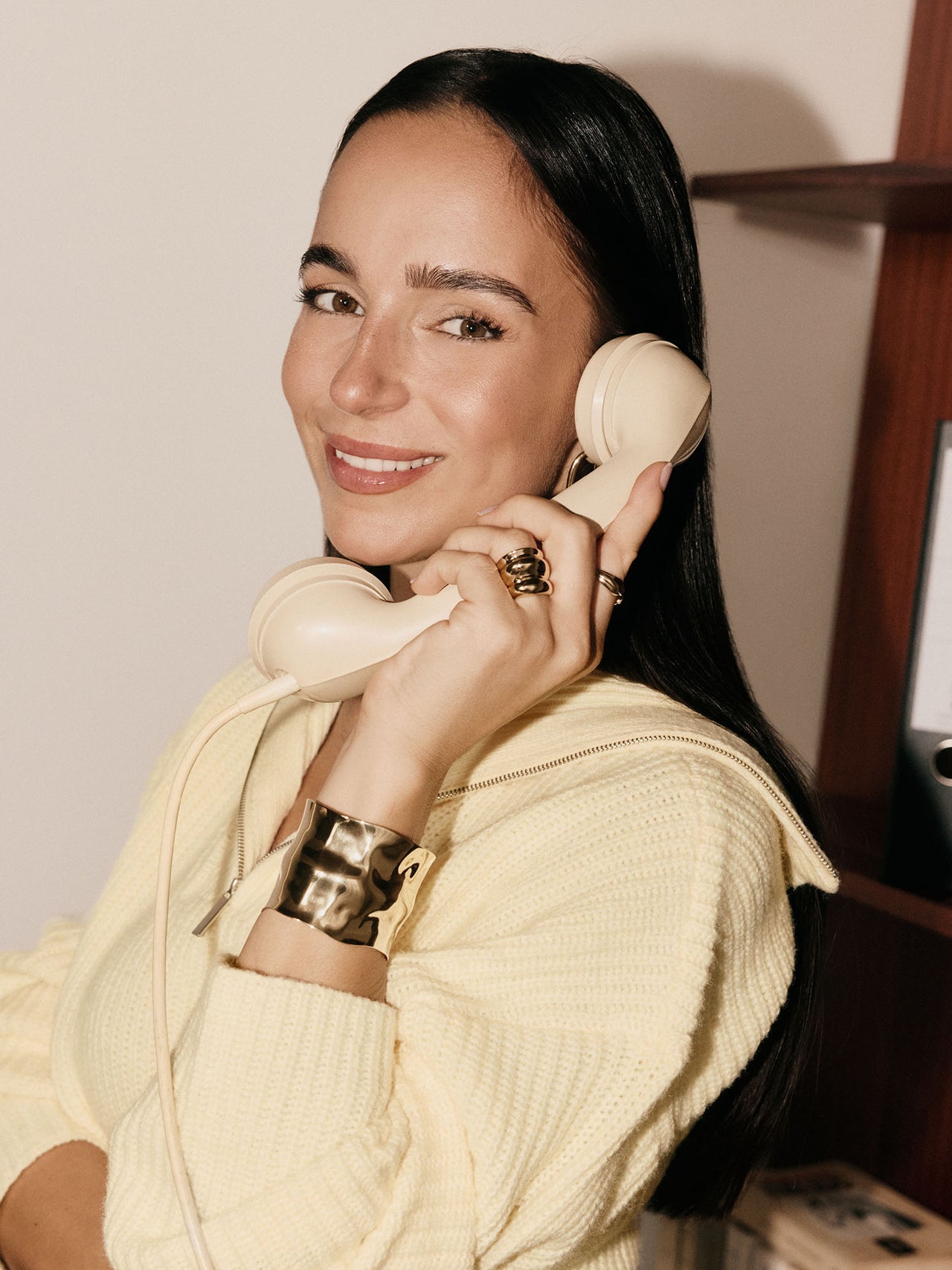 Elegantes, goldenes Armband und lächelnde Frau mit retro Telefon, PURELEI inspiriert.
