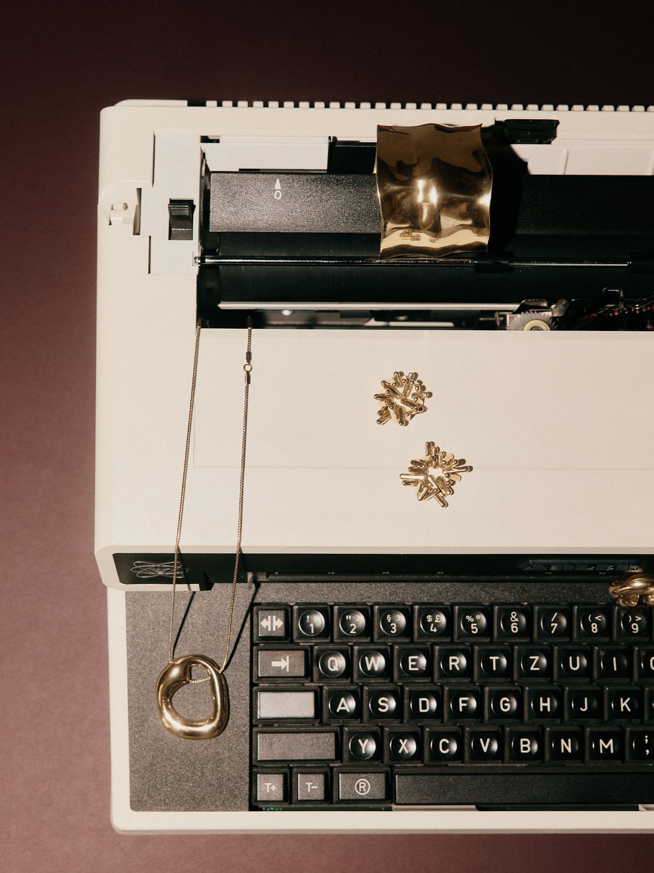 Silberne Kette mit organischem Anhänger auf Schreibmaschine, PURELEI inspiriert.