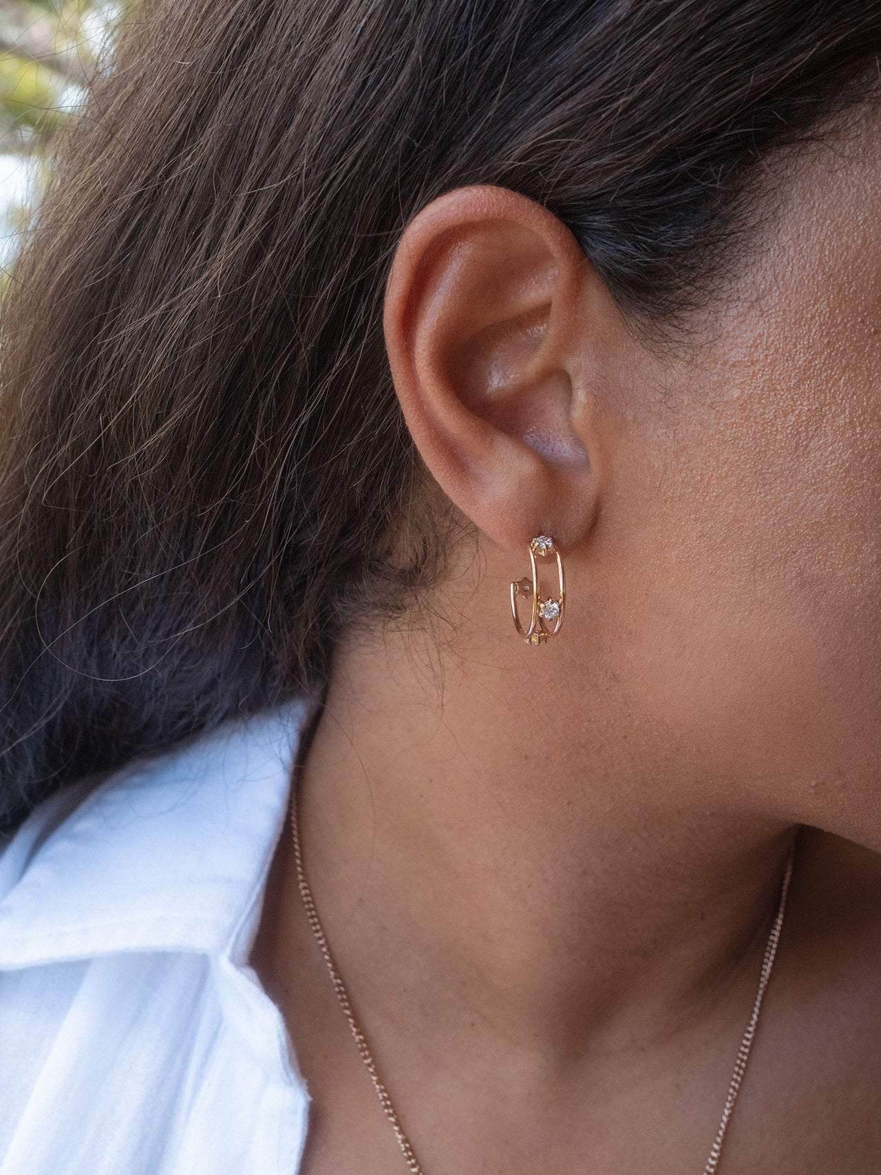 Roségoldene Creolen mit funkelndem Detail, getragen von PURELEI.