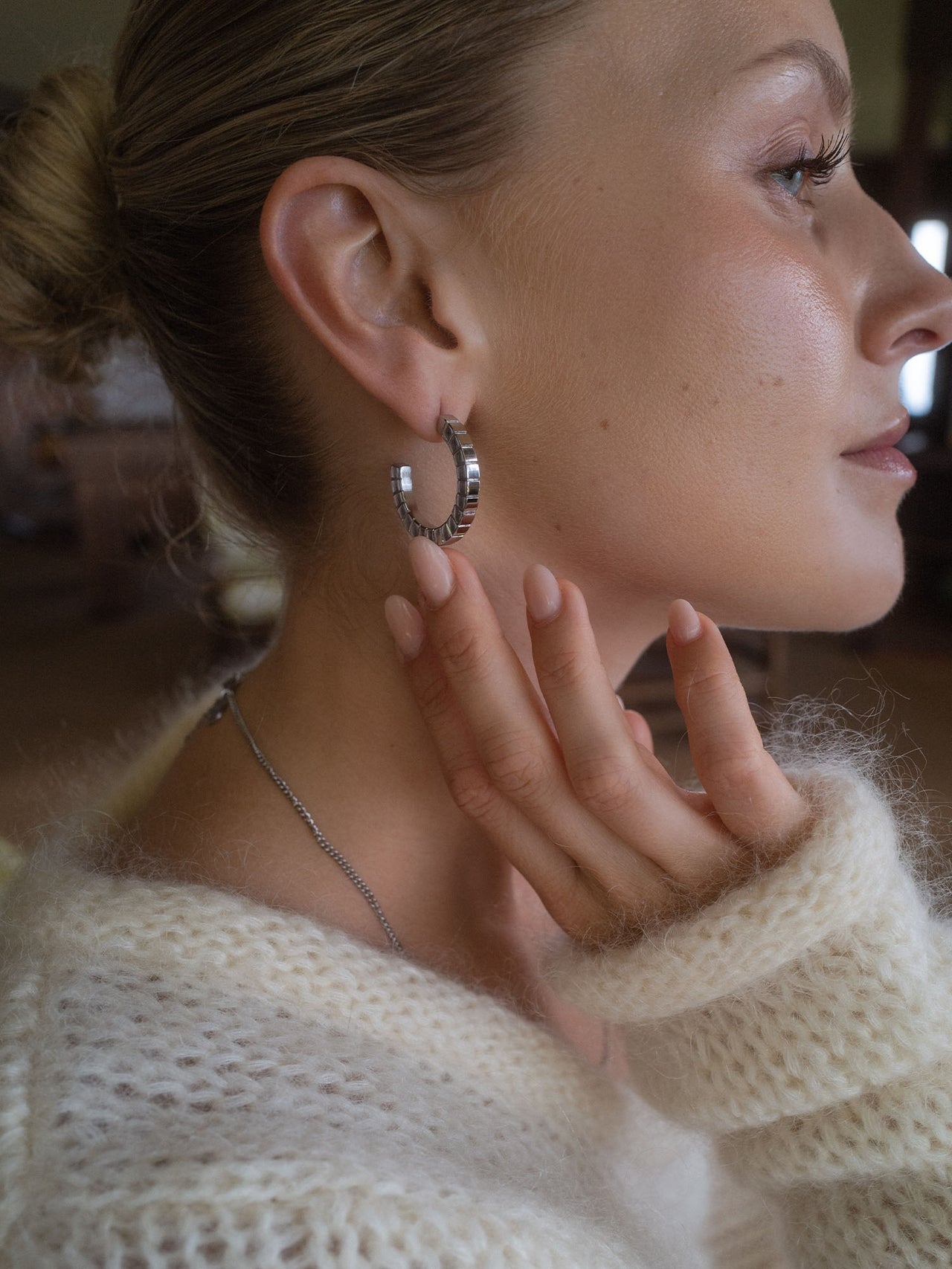 Silberne Creolen mit strukturiertem Design, getragen von einer Frau, PURELEI.