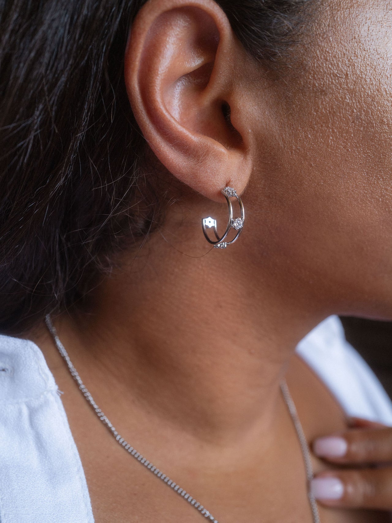 Silberne Creolen mit funkelnden Details, getragen am Ohr, von PURELEI.