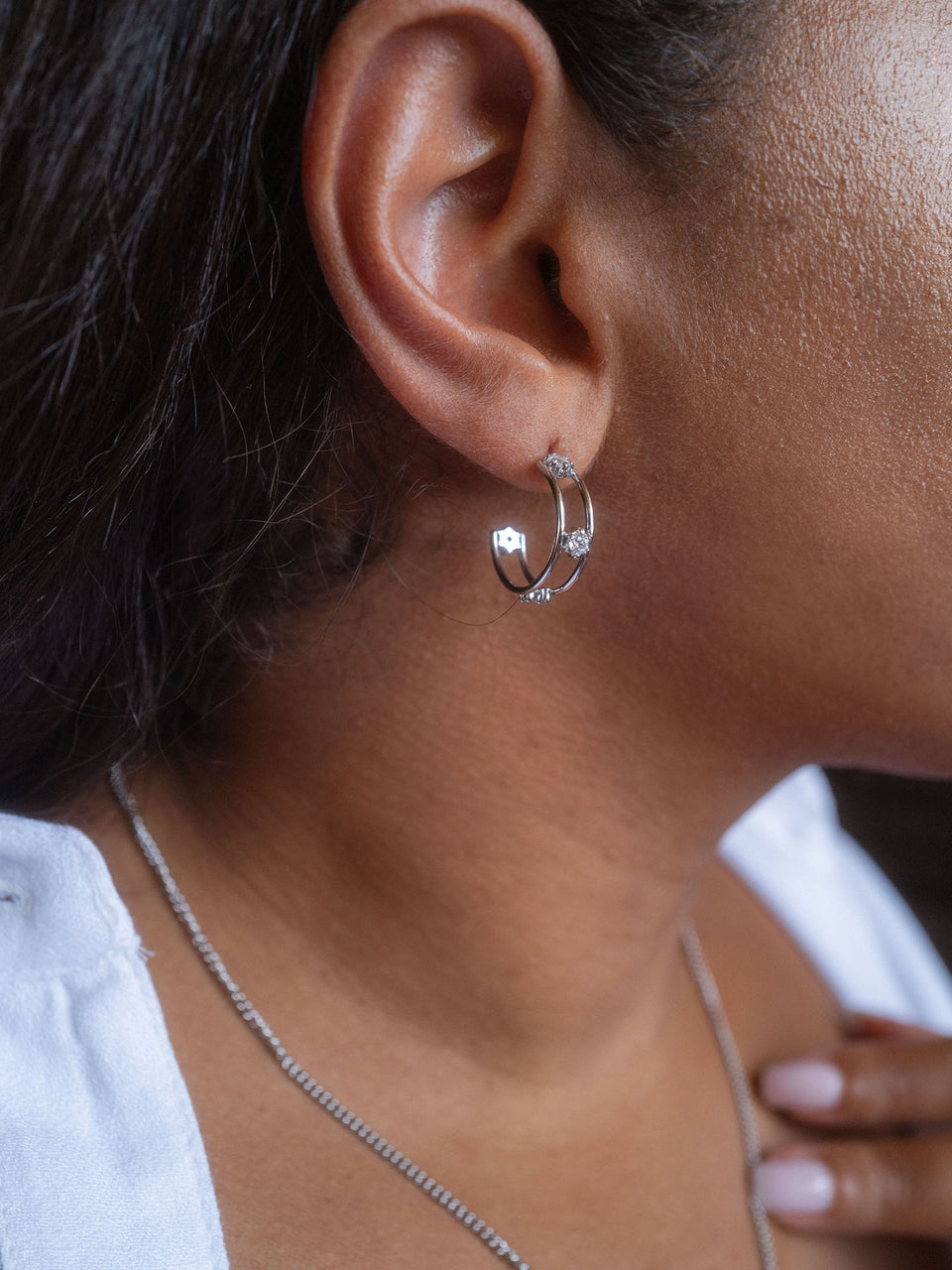 Silberne Creolen mit funkelnden Details, getragen am Ohr, von PURELEI.