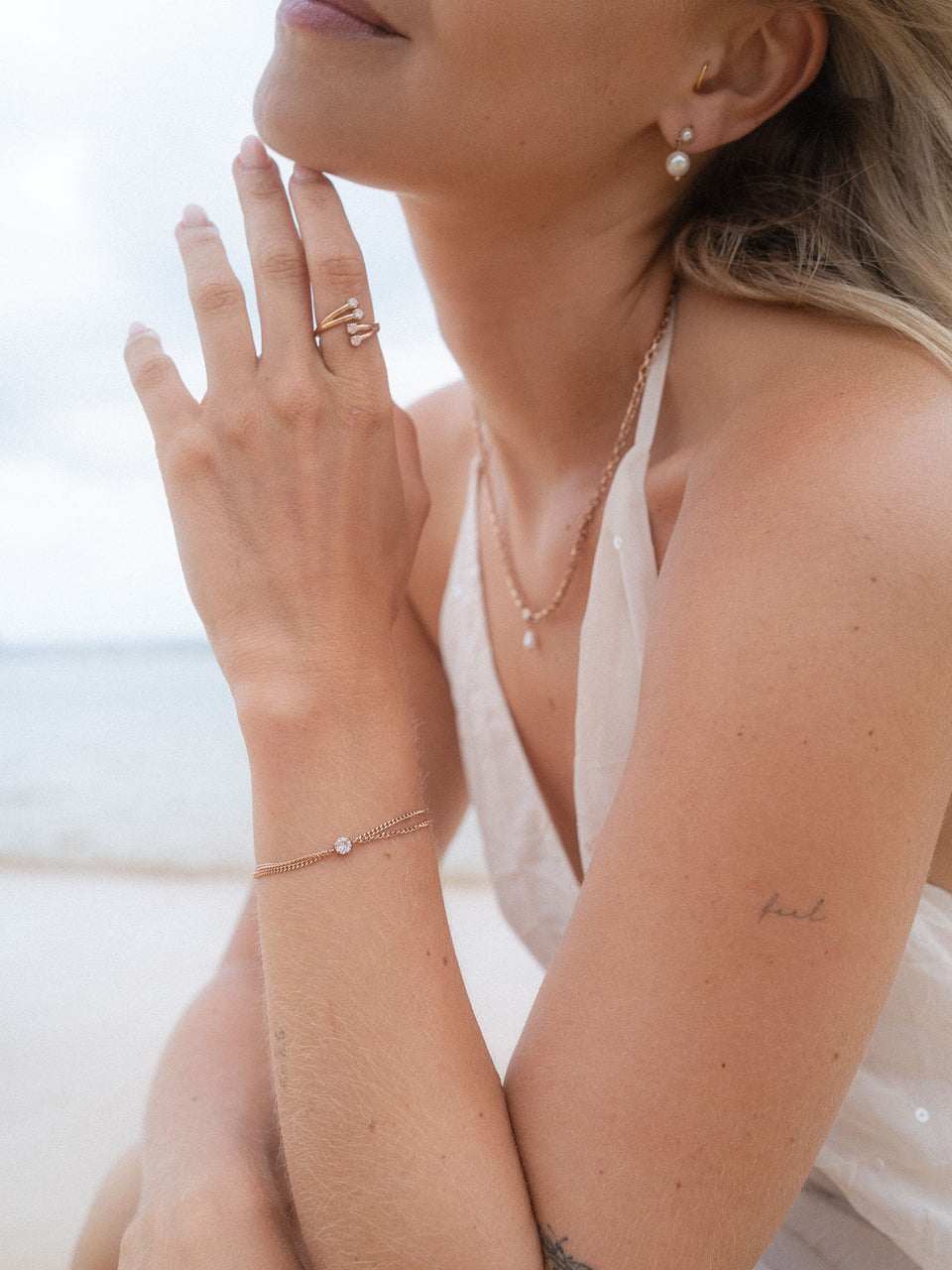 Elegante PURELEI Schmuckstücke aus Silber und Perlen, am Strand getragen, strahlen feminine Leichtigkeit aus.