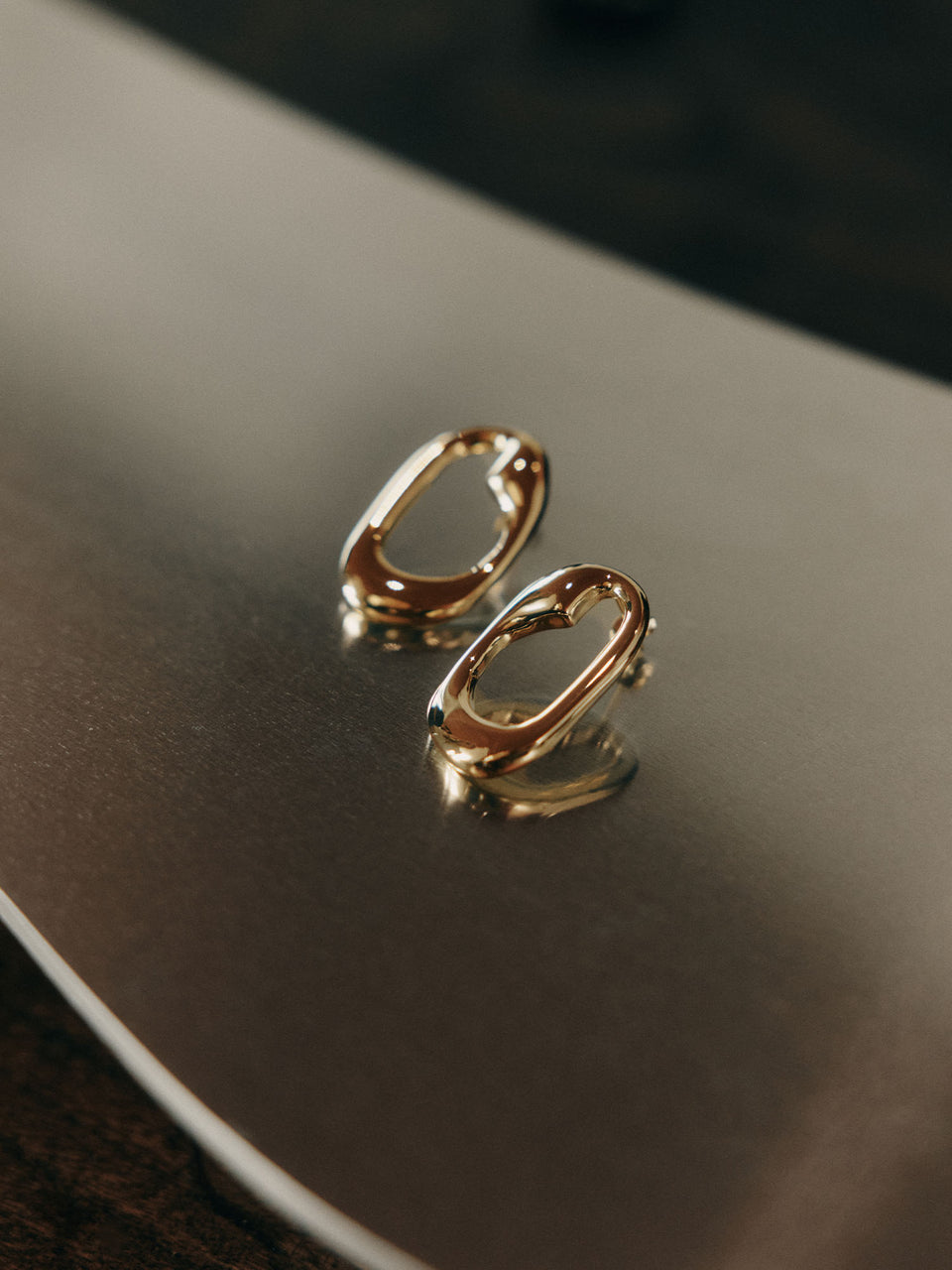 Silberne Ohrringe auf glänzendem Untergrund, elegant und modern – PURELEI.