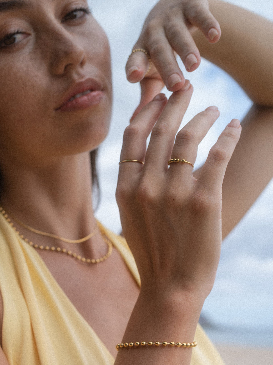 Zarte, roségoldene Ringe und Armband von PURELEI, elegant und feminin, am Handgelenk getragen.