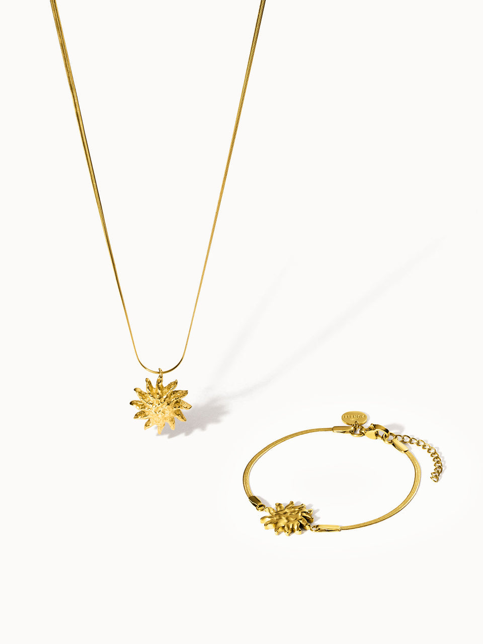 Goldene Kette und Armband mit Sonnenmotiv von PURELEI, elegant und strahlend.