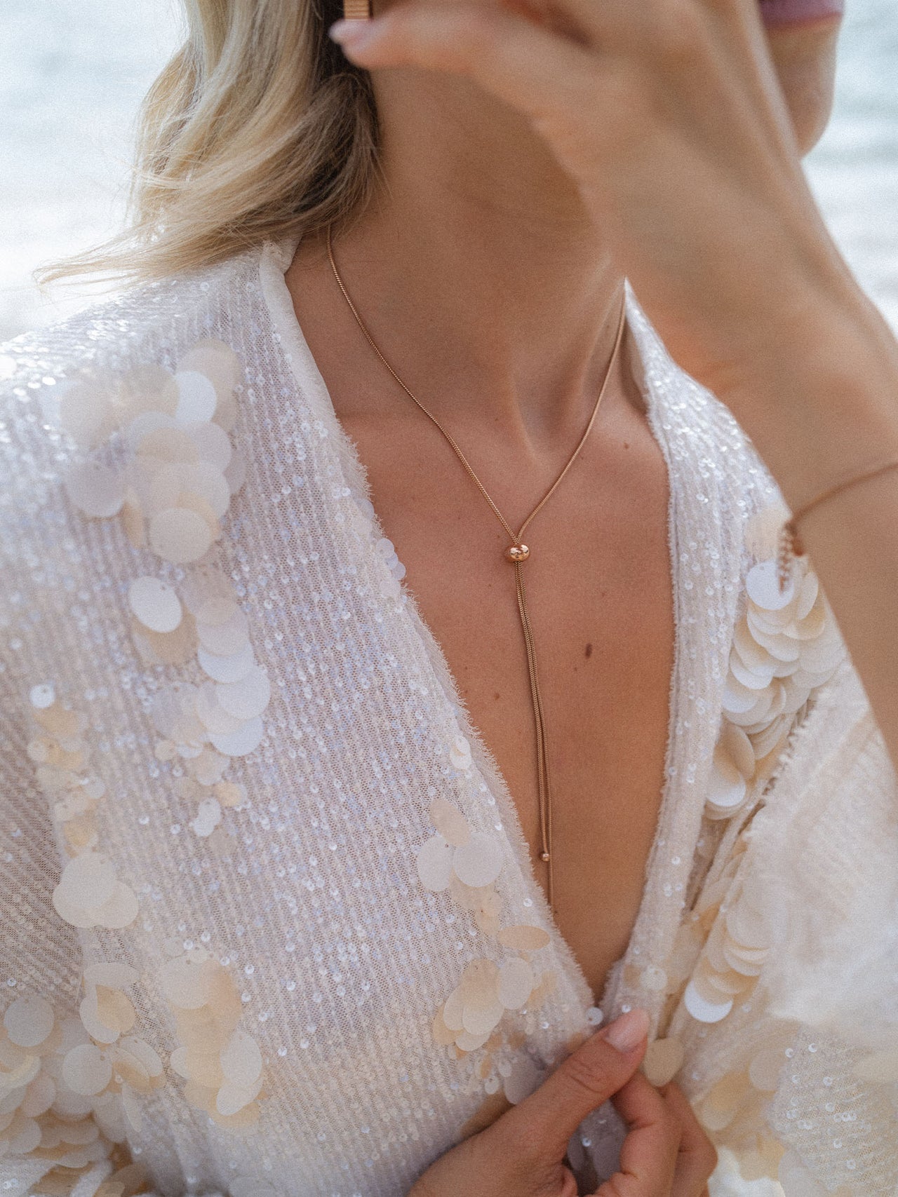 Elegante, roségoldene Kette mit Perle, getragen mit funkelndem Oberteil von PURELEI.