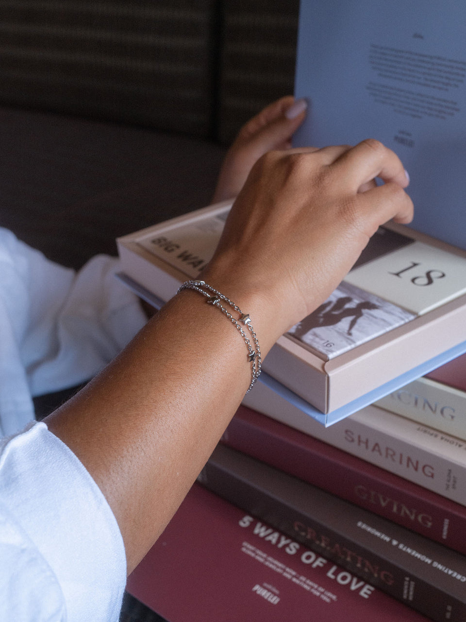Silbernes Armband mit zarten Details, getragen beim Lesen, inspiriert von PURELEI.
