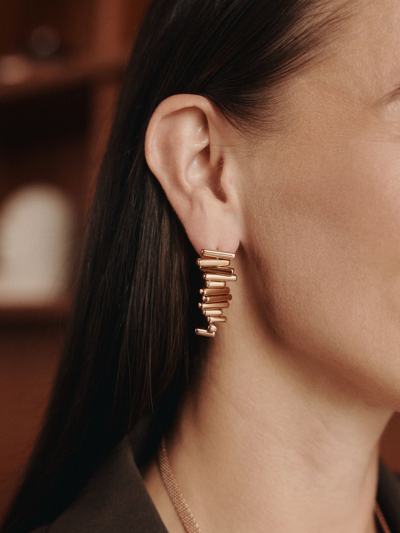 Roségoldene Ohrringe mit modernem Design, getragen von einer Frau, PURELEI.