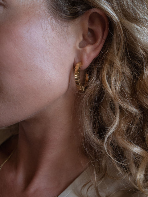 Roségoldene Creolen von PURELEI, elegant und modern, getragen in sanfter Lichtstimmung.