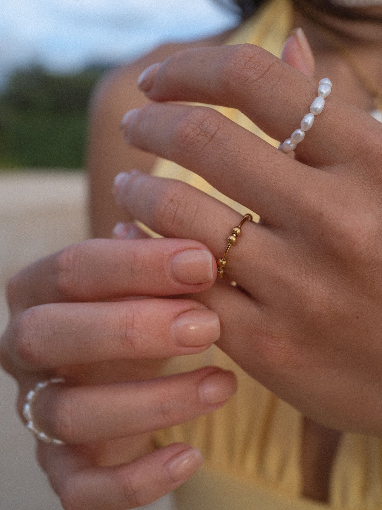 Zarte Ringe aus Roségold und Perlen, getragen an eleganten Händen, PURELEI inspiriert.