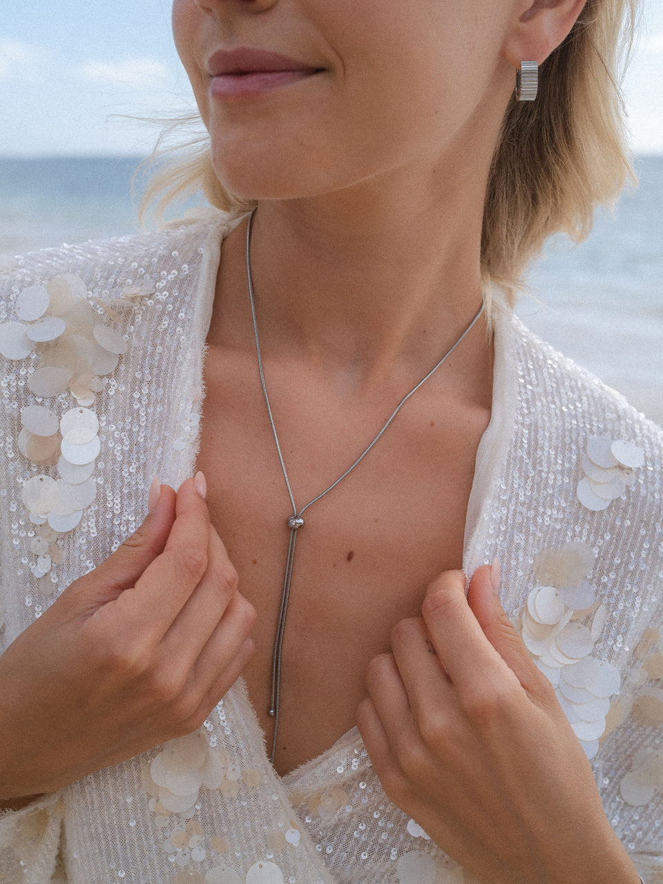 Silberne Kette mit minimalistischer Tropfenform, getragen in eleganter Umgebung – PURELEI.