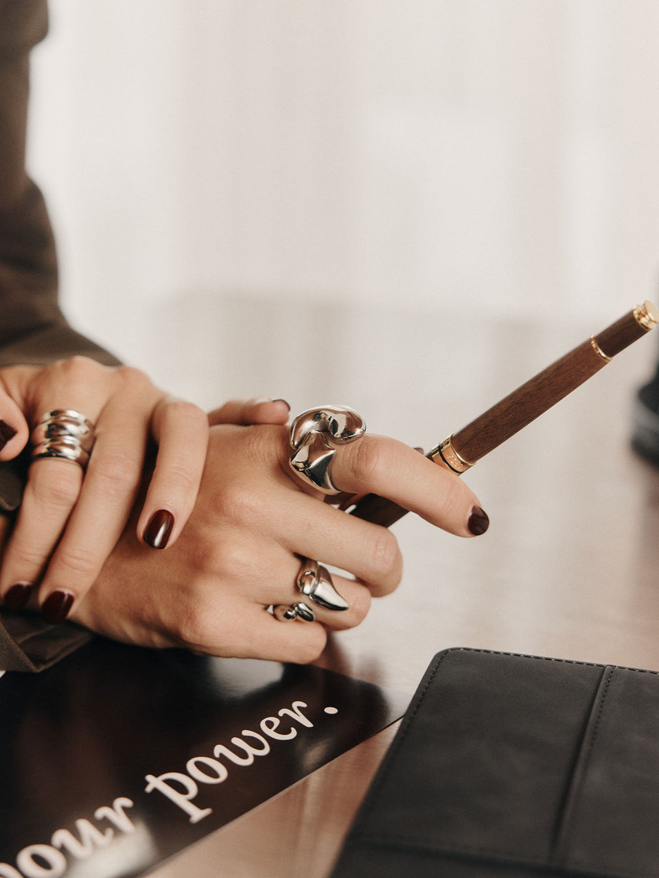 Silberne Ringe an einer Hand mit dunklem Nagellack, PURELEI inspiriert von Eleganz.