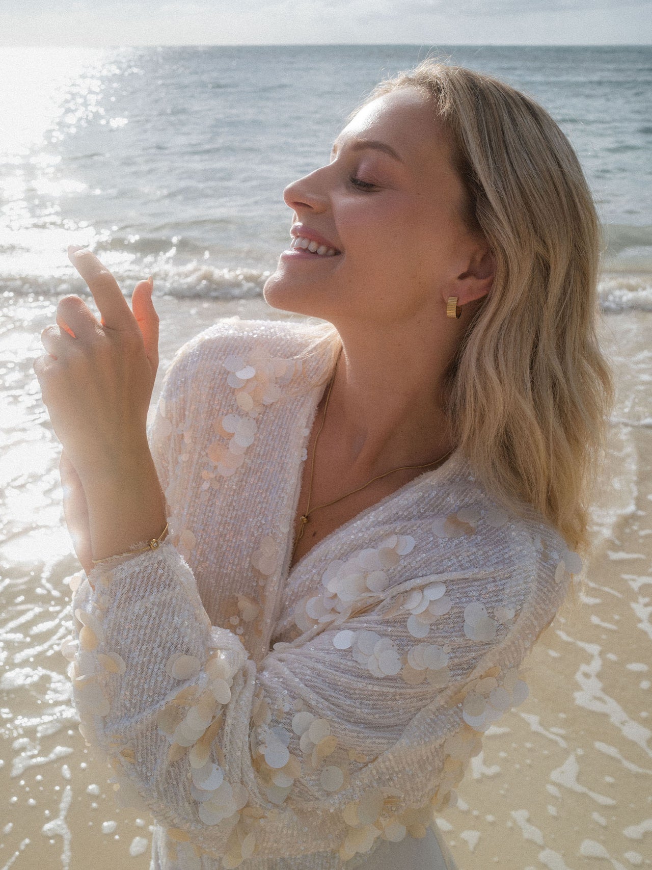 Feminine, glitzernde Bluse mit Muscheldetails am Strand, PURELEI inspiriert.