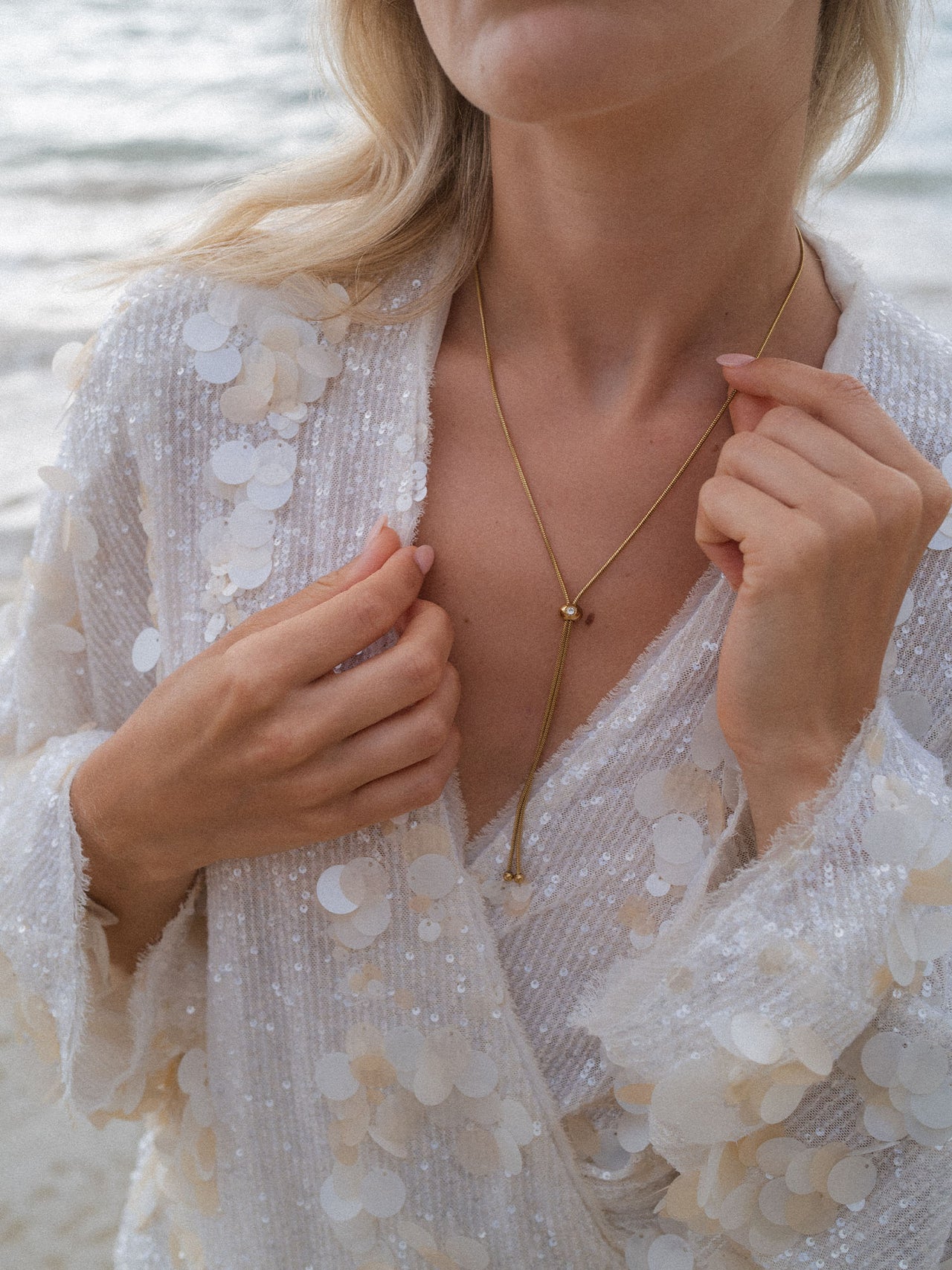 Roségoldene Kette mit zartem Anhänger, getragen in eleganter, glitzernder Umgebung – PURELEI.