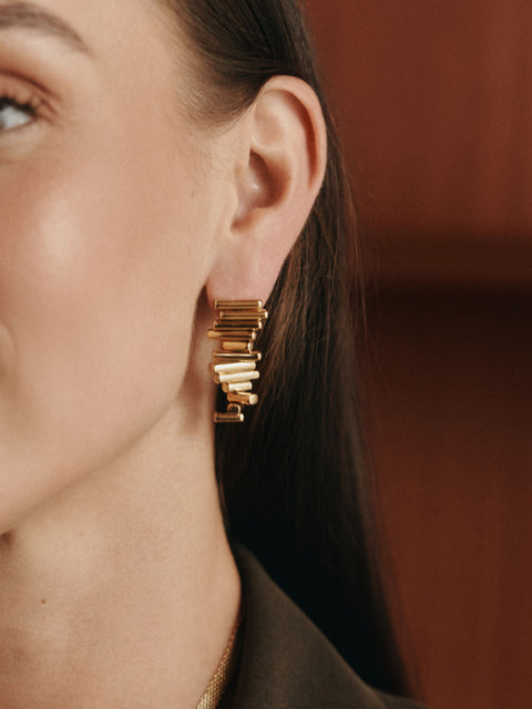 Roségoldene Ohrringe mit modernem Design, getragen von einer Frau, PURELEI.