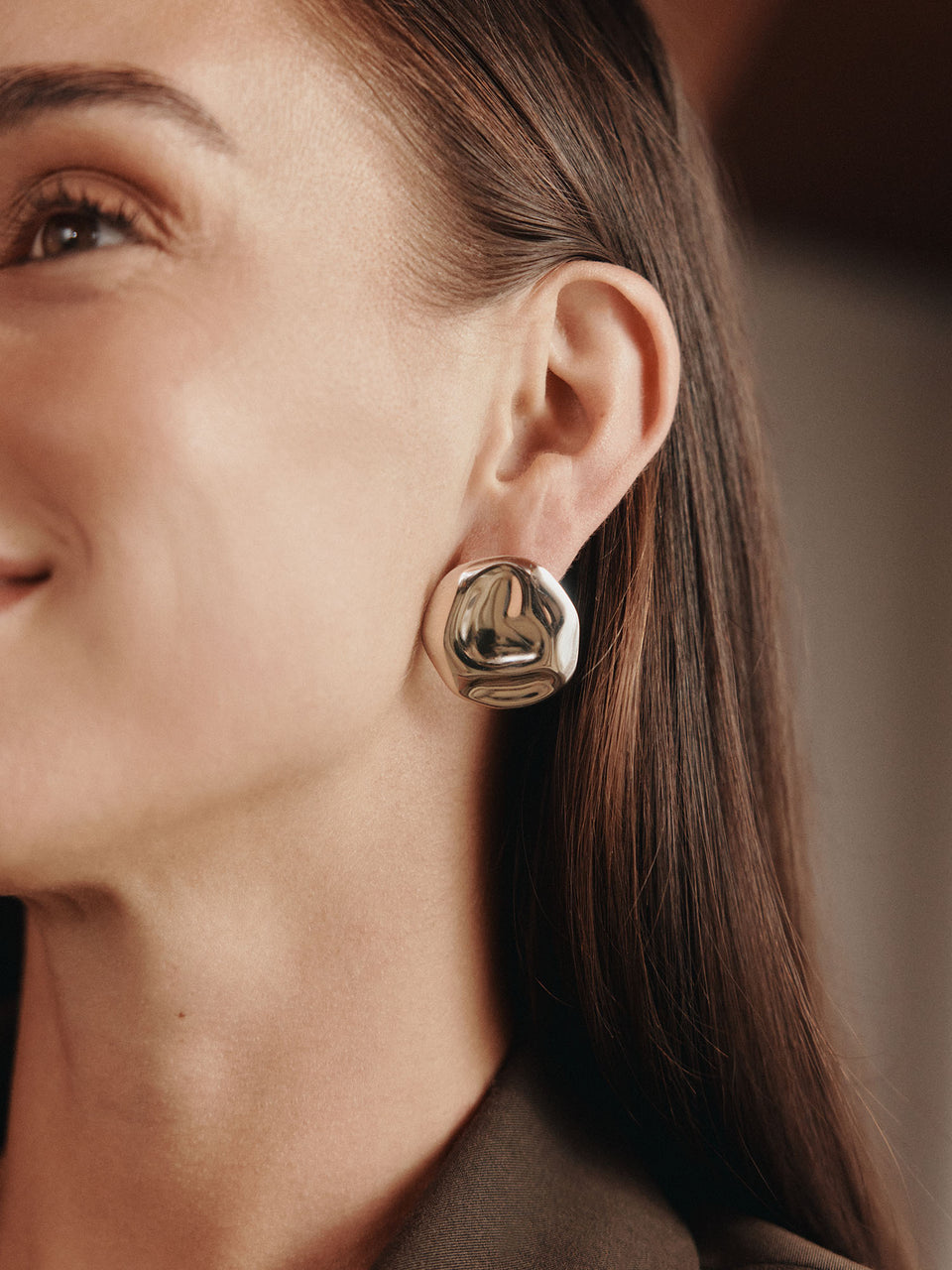 Glänzende, organisch geformte Ohrringe aus Silber, getragen von einer Frau mit natürlichem Lächeln – PURELEI.