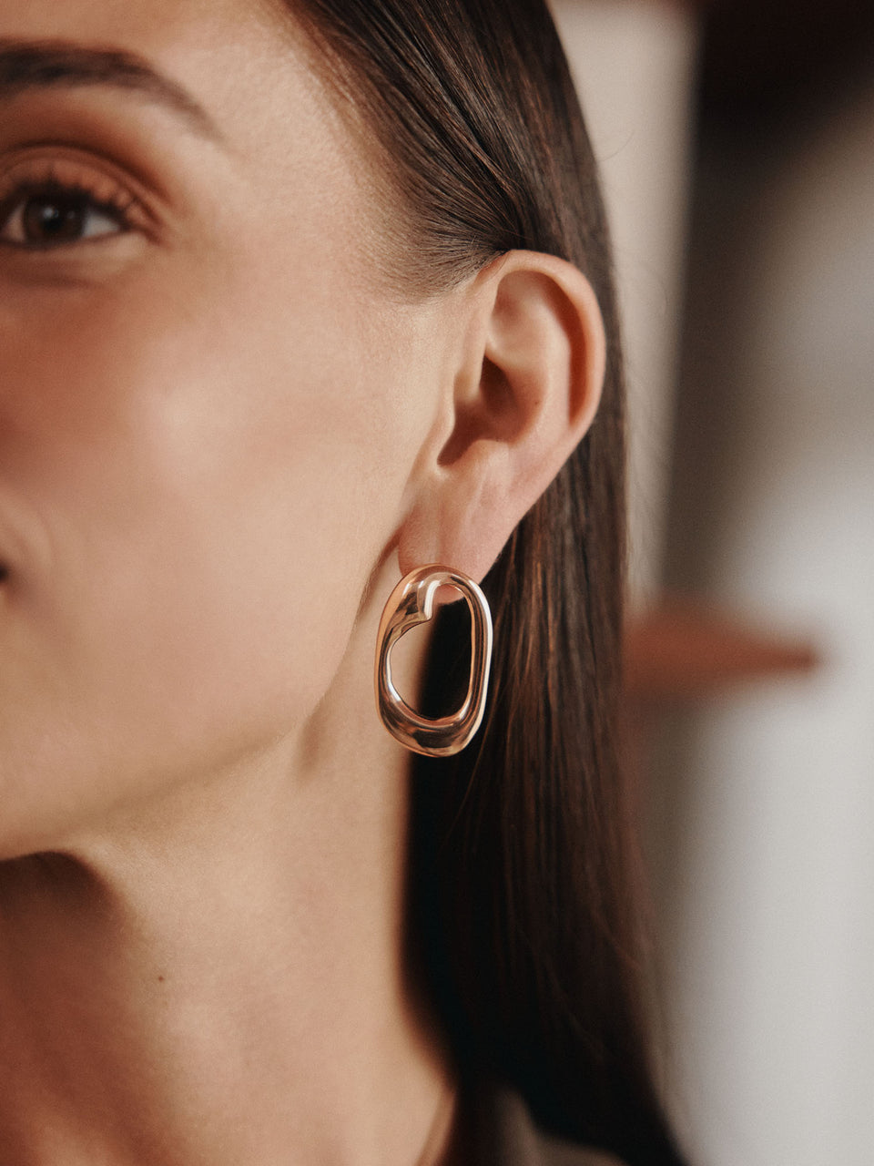 Roségoldene Creolen mit organischer Form, getragen von einer Frau, PURELEI.