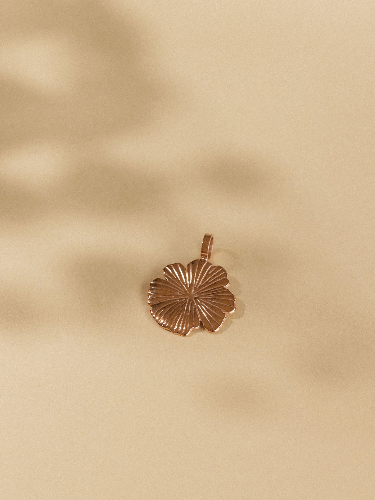 Bronzener Hibiskus-Anhänger auf sanftem Hintergrund, PURELEI inspiriert.