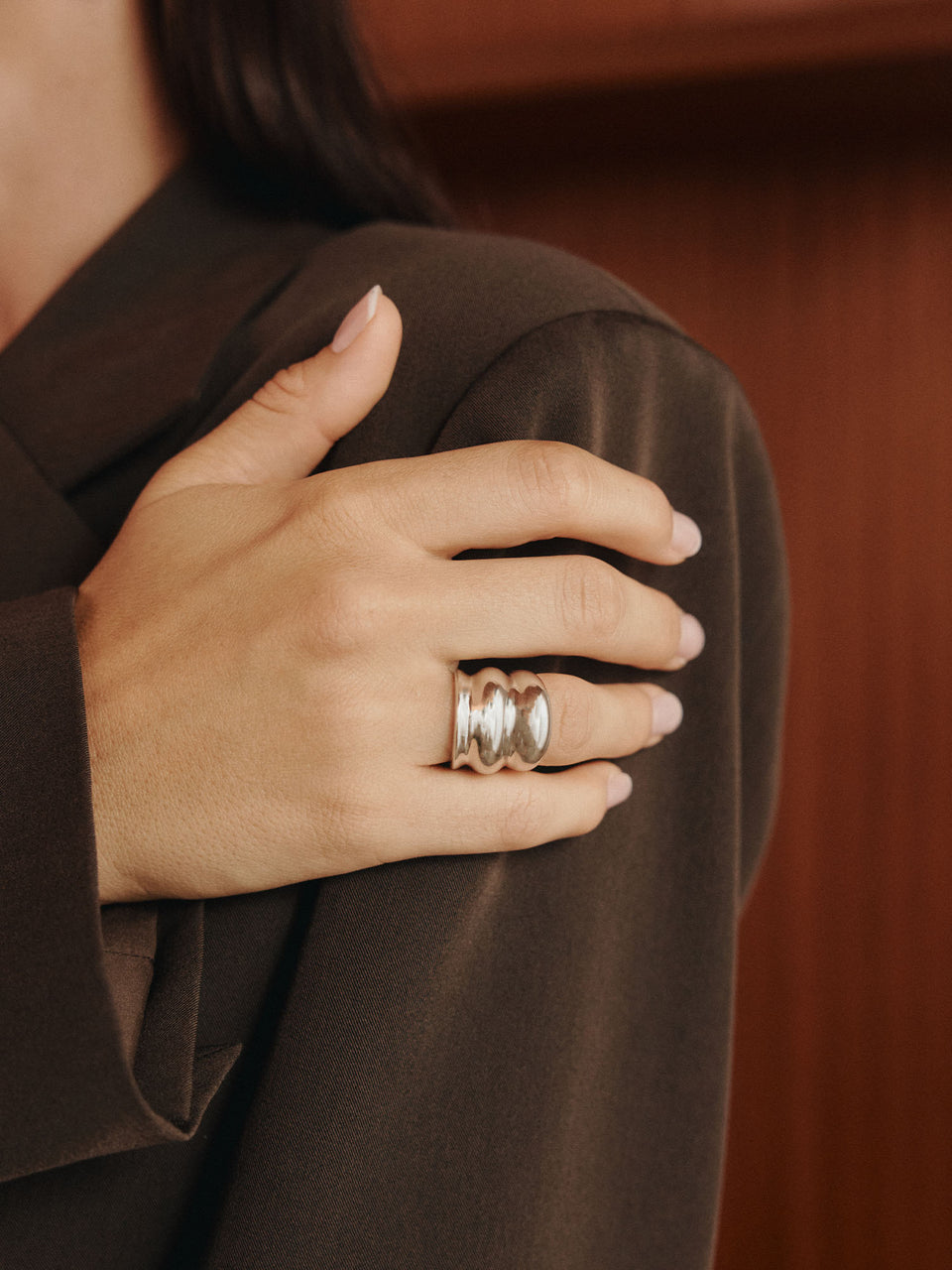 Roségoldener Ring mit geschwungenem Design, getragen an elegantem Outfit von PURELEI.