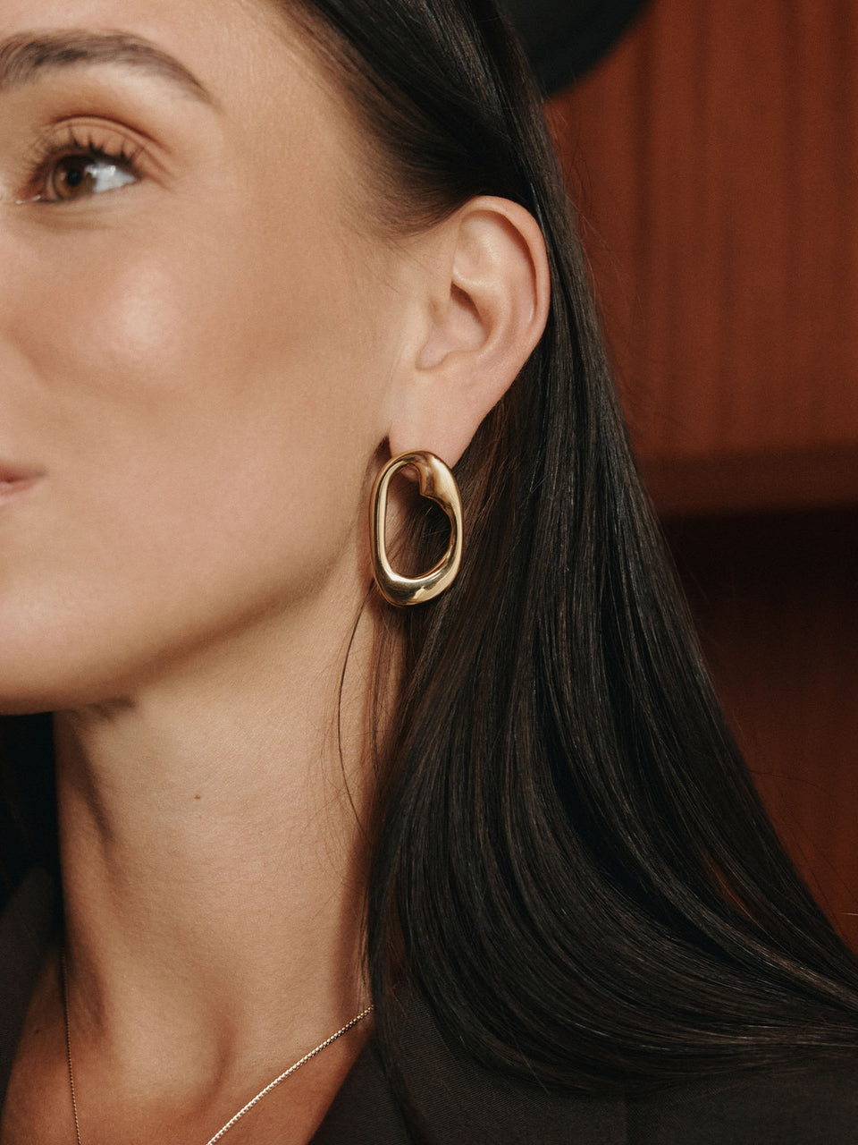 Roségoldene Creolen mit elegantem Design, getragen von einer Frau, PURELEI inspiriert.