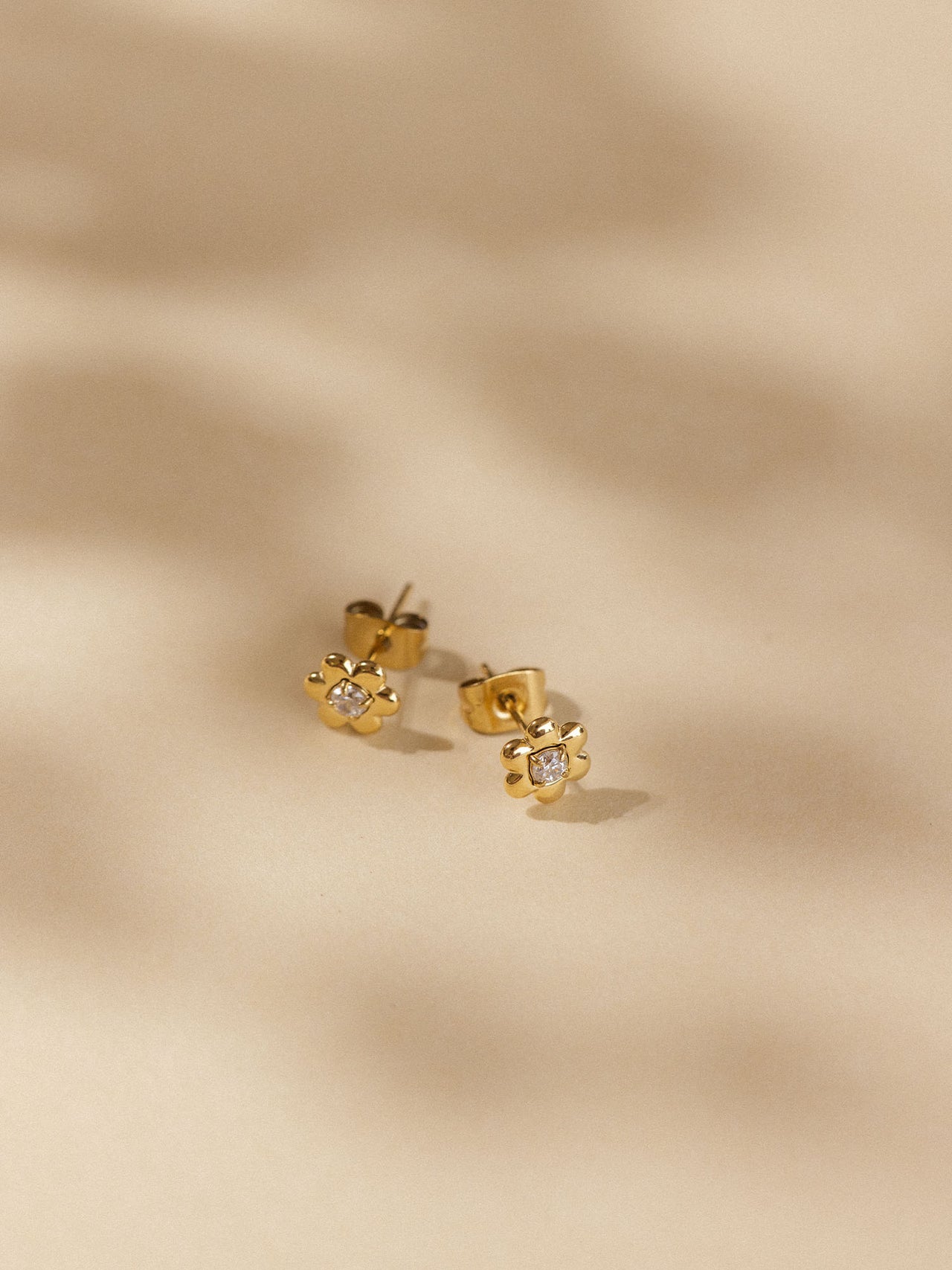 Goldene Blütenohrringe mit funkelnden Details von PURELEI, elegant und feminin.