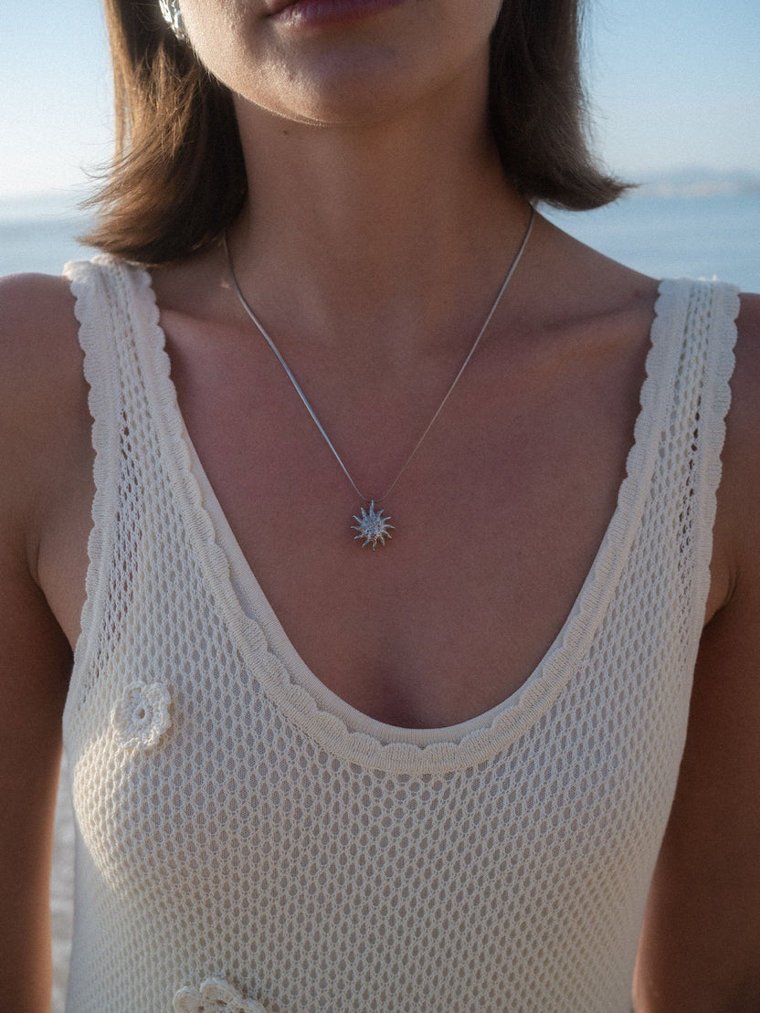 Silberne Kette mit Sonnenanhänger, getragen in natürlichem Licht, PURELEI.