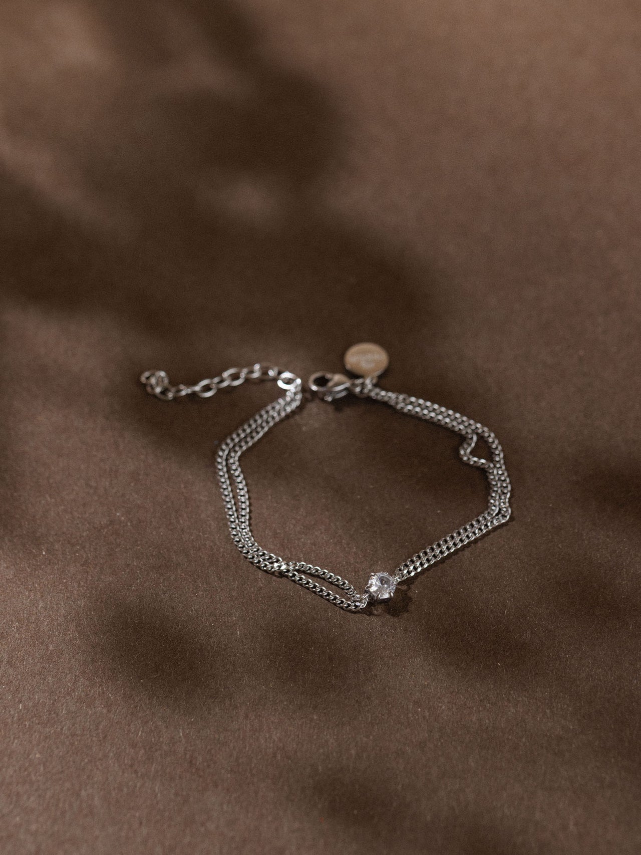 Silbernes Armband mit feiner Kettenstruktur, elegant auf dunklem Hintergrund, PURELEI.