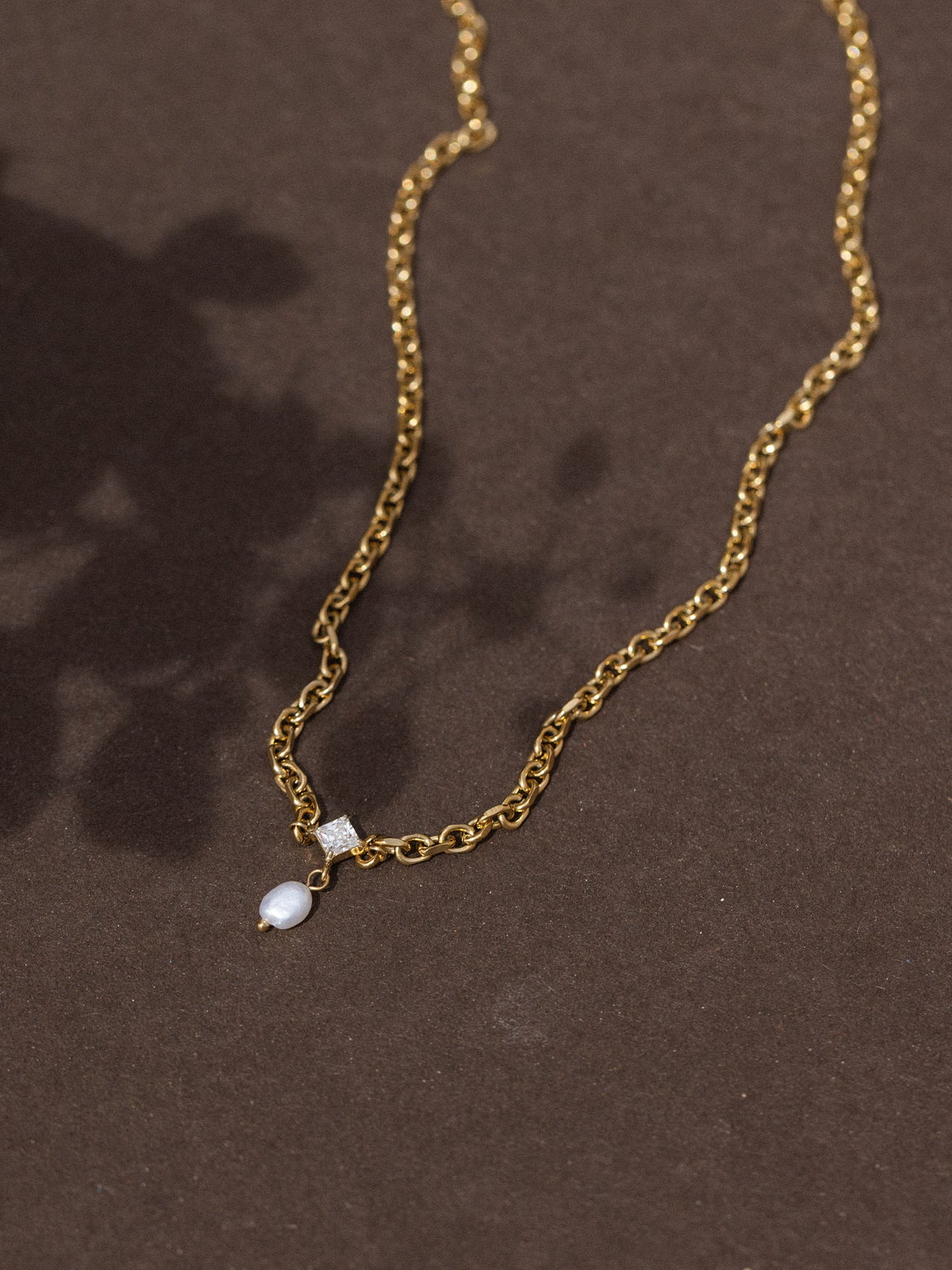 Goldene Kette mit Anhänger, elegant auf dunklem Hintergrund, von PURELEI.