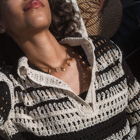 Goldene Kette mit Sternen und Mond, getragen mit lässigem, gestreiften Oberteil – PURELEI.