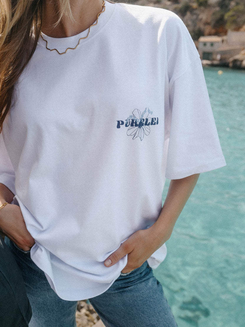 Blue Paradise T-Shirt aus weißer Baumwolle mit blauem Hibiskus-Print, feminine PURELEI Leichtigkeit am Meer.