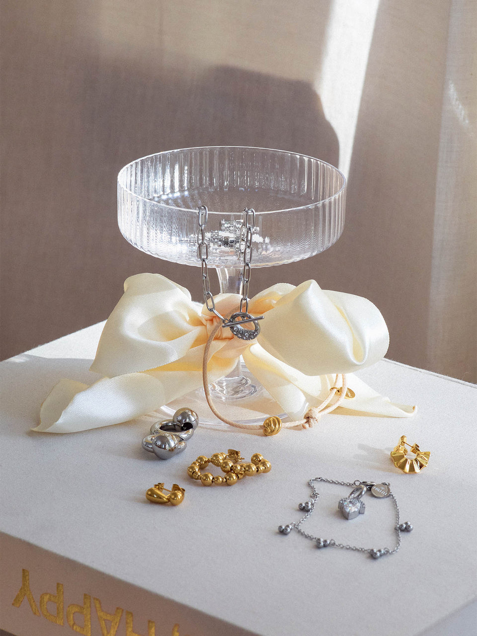 Silberne und goldene Schmuckstücke auf einem weißen Tuch, inspiriert von PURELEI.