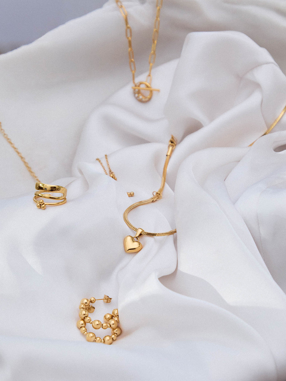 PURELEI Adventskalender 2024, goldene, nickelfreie Schmuckstücke auf elegantem, weißem Stoff, feminine Leichtigkeit