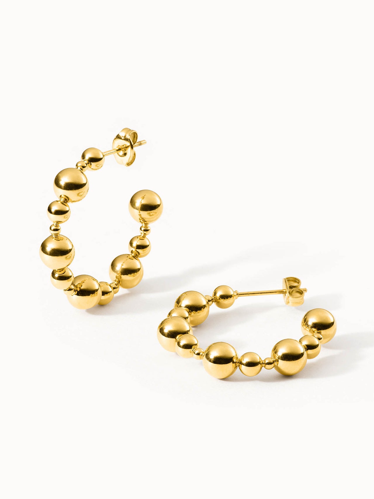 Goldene Creolen mit kugelförmigen Details von PURELEI, elegant und modern.