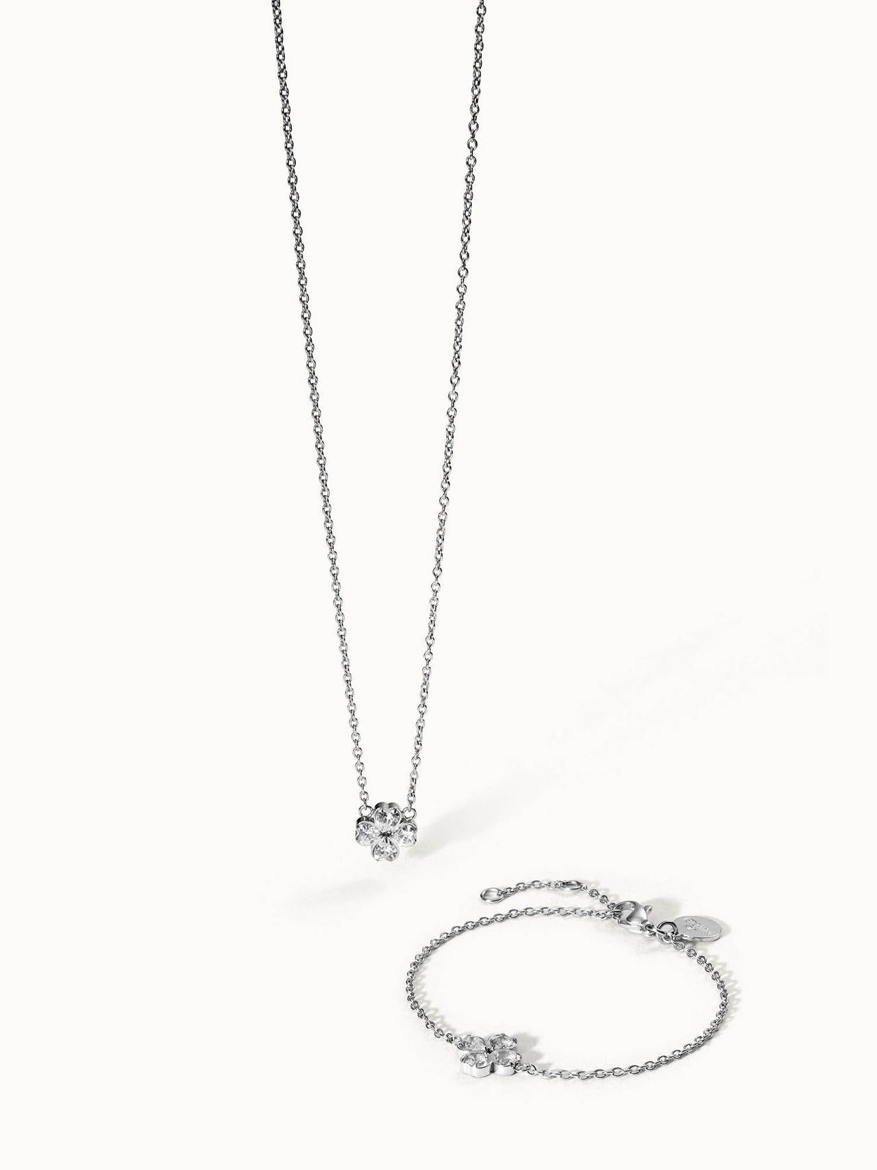 Silberne Kette und Armband mit blütenförmigem Anhänger von PURELEI, elegant und feminin.