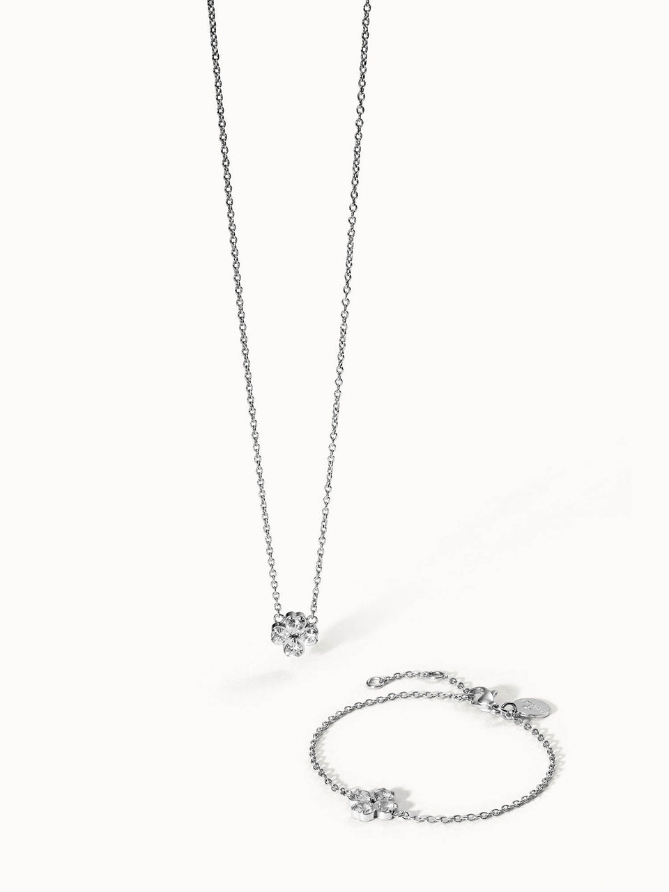 Silberne Kette und Armband mit blütenförmigem Anhänger von PURELEI, elegant und feminin.