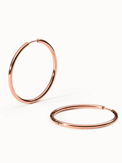 Roségoldene Creolen von PURELEI, elegant und modern, auf hellem Hintergrund.