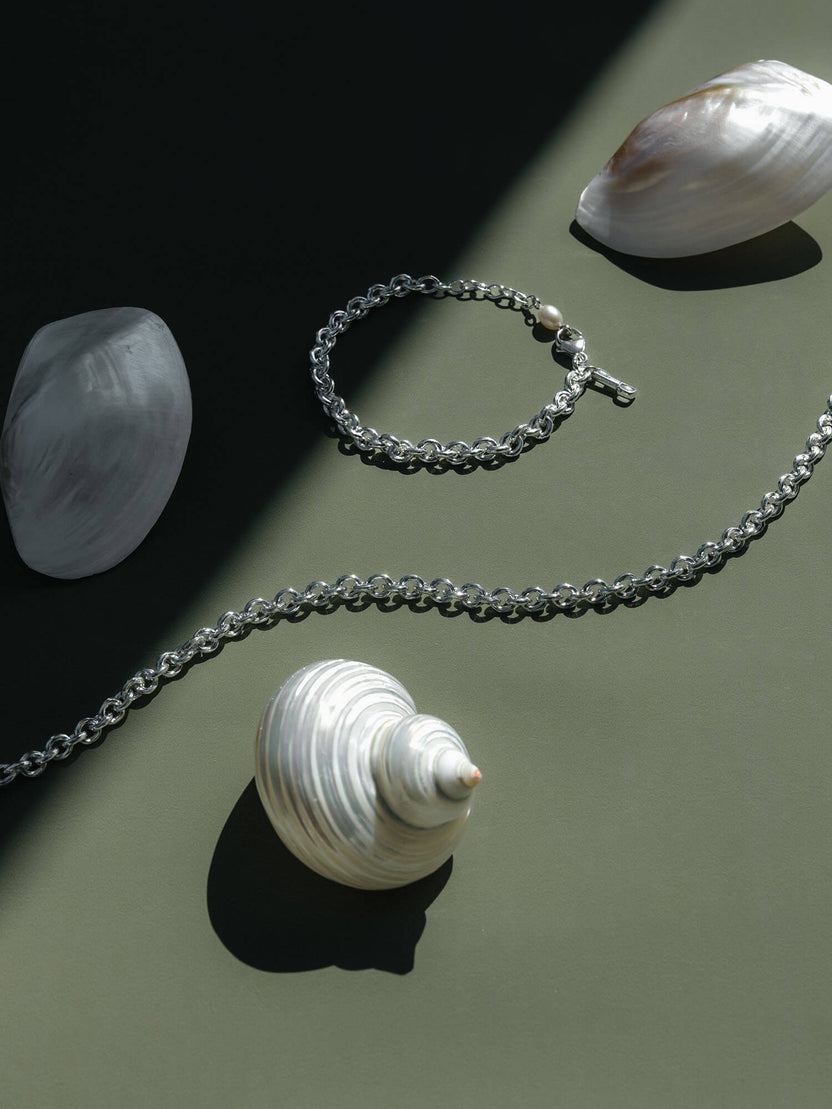 PURELEI Dream Kette aus recyceltem Silber mit schimmernder Süßwasserperle auf grünem Untergrund, elegant.